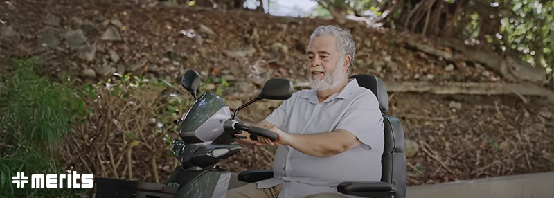 Older man riding scooter outside