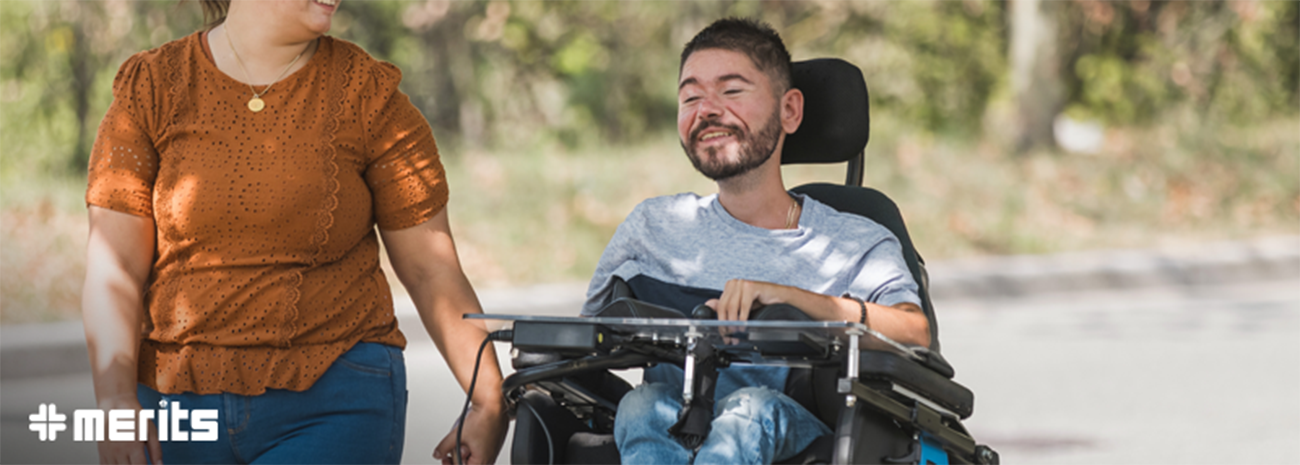 Man in power wheelchair smiling and riding outside
