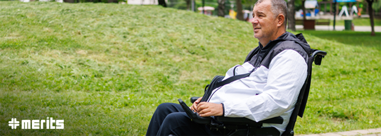 Older, heavier set man in a power wheelchair outdoors